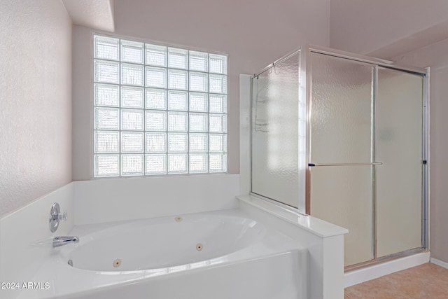 bathroom with a healthy amount of sunlight, separate shower and tub, and tile patterned flooring