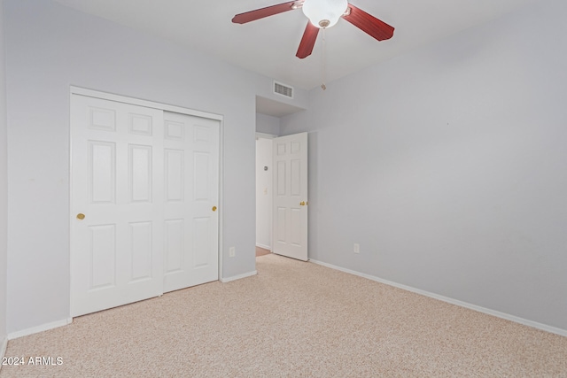 unfurnished bedroom featuring light colored carpet, a closet, and ceiling fan