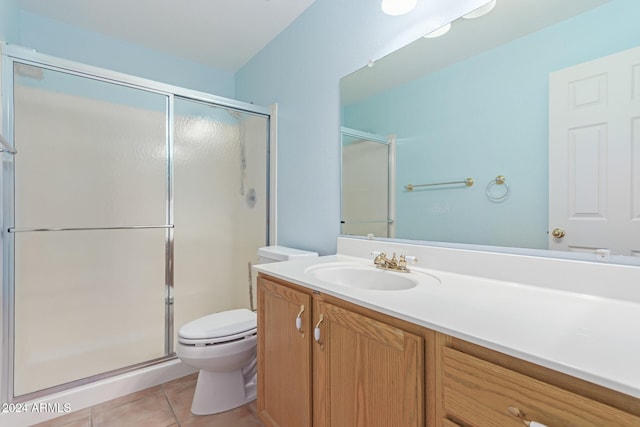 bathroom featuring vanity, tile patterned flooring, toilet, and a shower with door