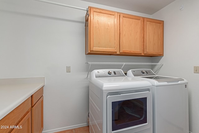 laundry area with cabinets and washing machine and clothes dryer