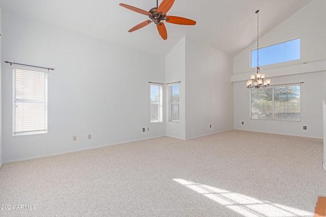 empty room with light carpet, ceiling fan with notable chandelier, and high vaulted ceiling