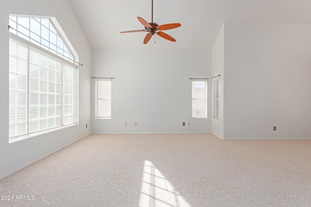 empty room with vaulted ceiling, light colored carpet, and ceiling fan