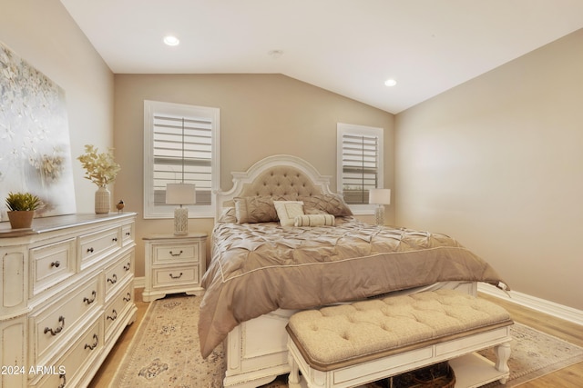 bedroom with vaulted ceiling and light hardwood / wood-style flooring