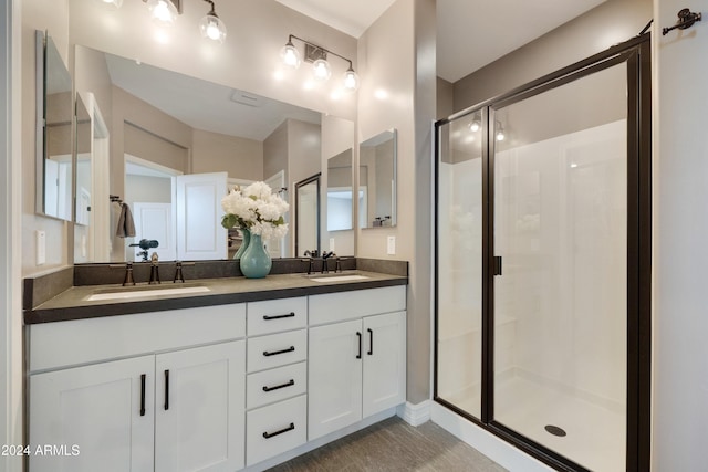 bathroom with a shower with door and vanity