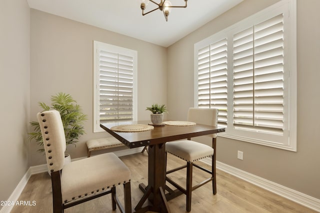 dining room featuring light hardwood / wood-style flooring, a healthy amount of sunlight, and a notable chandelier