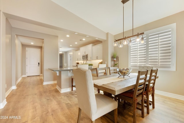 dining room with light hardwood / wood-style floors and lofted ceiling