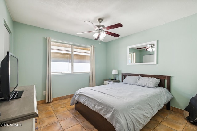 bedroom with ceiling fan and light tile patterned floors