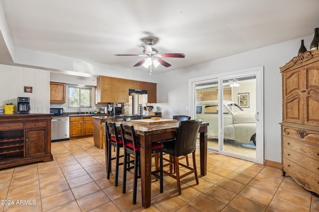 tiled dining room featuring ceiling fan and sink