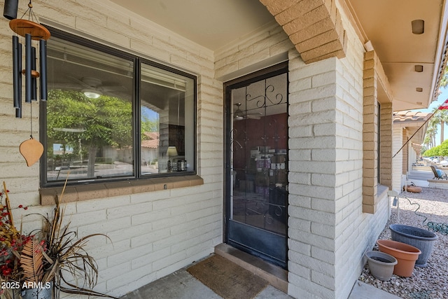 doorway to property featuring brick siding