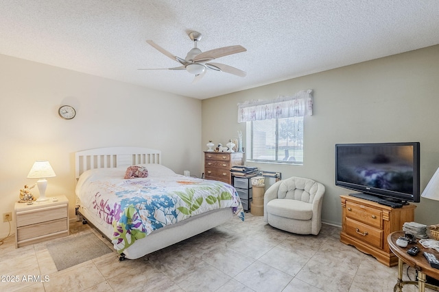 bedroom featuring light tile patterned floors, ceiling fan, and a textured ceiling