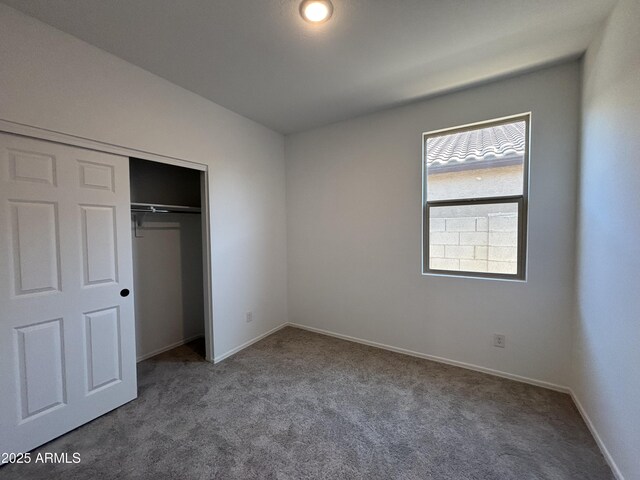 unfurnished bedroom featuring a closet, baseboards, and carpet floors