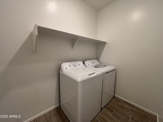 laundry room with washer and dryer, baseboards, wood tiled floor, and laundry area