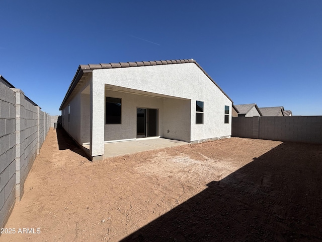 back of property with stucco siding, a fenced backyard, and a patio area