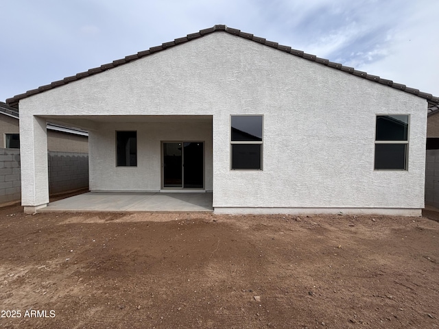 back of house with a patio, fence, and stucco siding