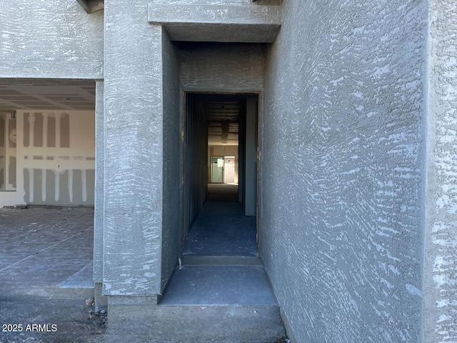 doorway to property featuring stucco siding