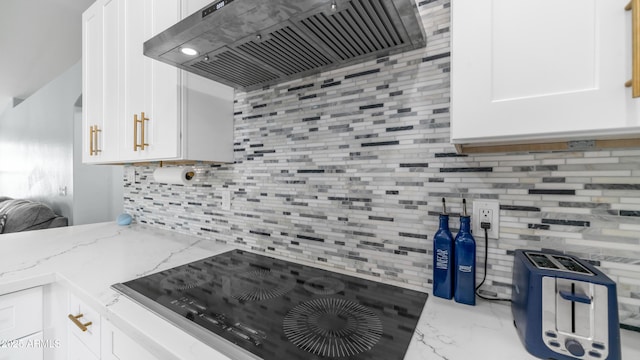 kitchen featuring premium range hood, decorative backsplash, white cabinetry, black electric stovetop, and marble look tile flooring
