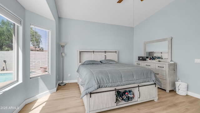bedroom featuring lofted ceiling, light wood-type flooring, baseboards, and ceiling fan