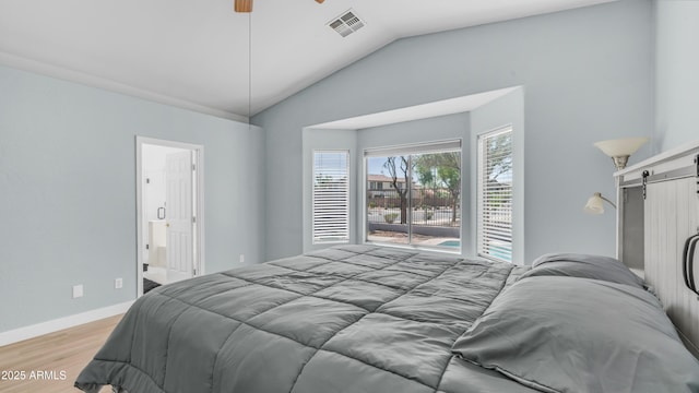 bedroom featuring a barn door, light wood finished floors, lofted ceiling, access to outside, and baseboards
