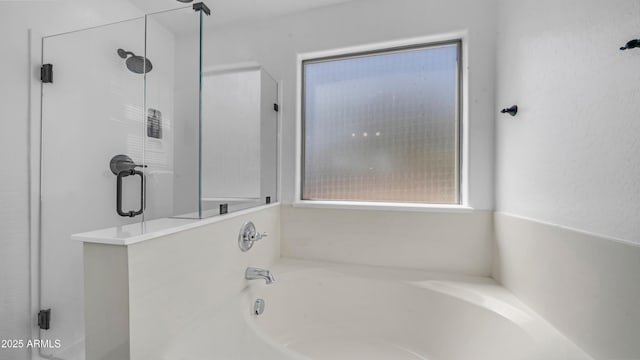 full bathroom featuring a shower stall and a garden tub