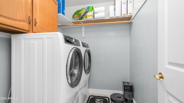 laundry area with washer and clothes dryer, cabinet space, tile patterned floors, and baseboards