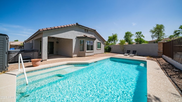 view of pool featuring a hot tub, a fenced backyard, and a patio