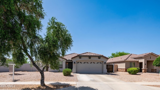 mediterranean / spanish house with stucco siding, a tile roof, a garage, and driveway