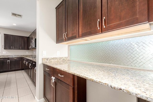 2920 E Virginia St E, Mesa, AZ 85213 - kitchen with light stone countertops, dark brown cabinetry, light tile patterned flooring, and recessed lighting