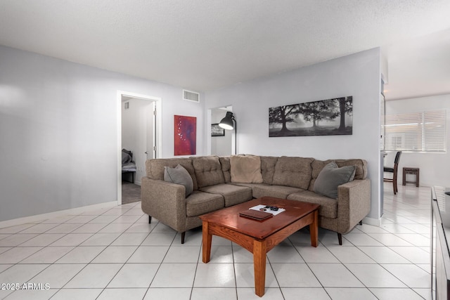 tiled living room featuring a textured ceiling