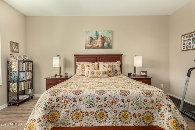 bedroom with baseboards and wood finished floors