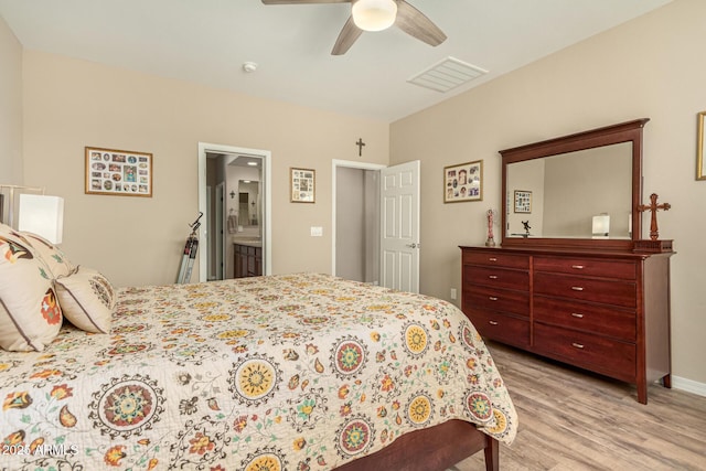 bedroom featuring visible vents, light wood-style flooring, ceiling fan, ensuite bath, and baseboards