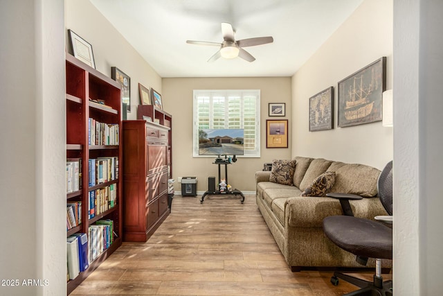 living area with ceiling fan, light wood-type flooring, and baseboards