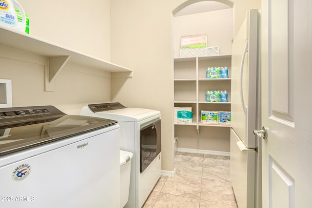 laundry room with laundry area, independent washer and dryer, and baseboards