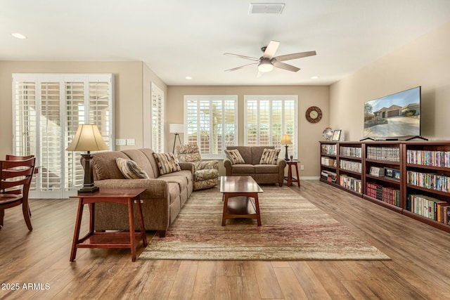 living room featuring a ceiling fan, visible vents, wood finished floors, and recessed lighting