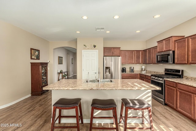 kitchen with stainless steel appliances, visible vents, a sink, and a breakfast bar area