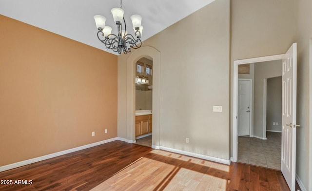 unfurnished room featuring hardwood / wood-style floors and a notable chandelier