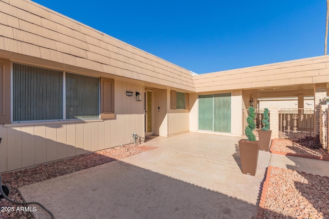 view of exterior entry featuring a patio