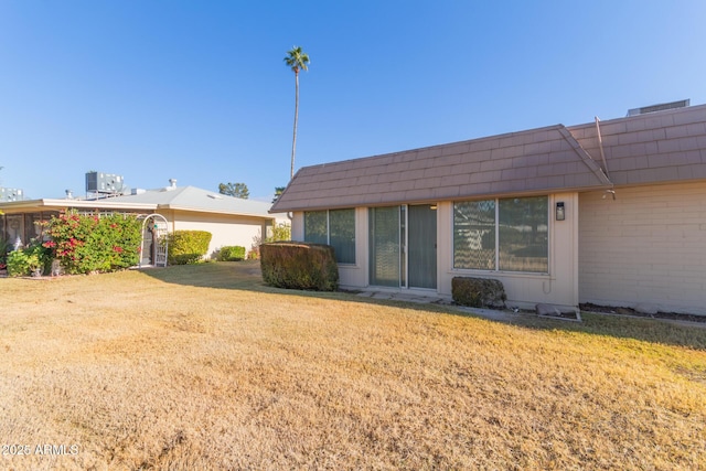 back of property featuring central AC and a yard