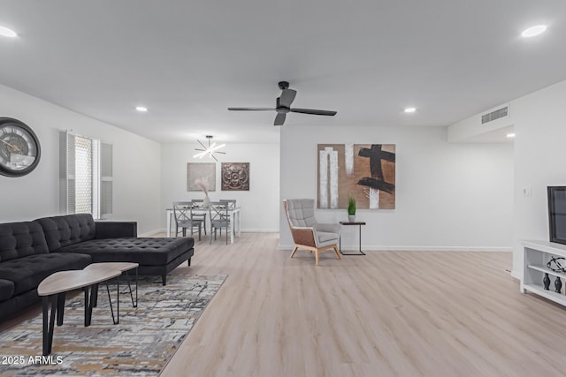 living room with ceiling fan and light wood-type flooring