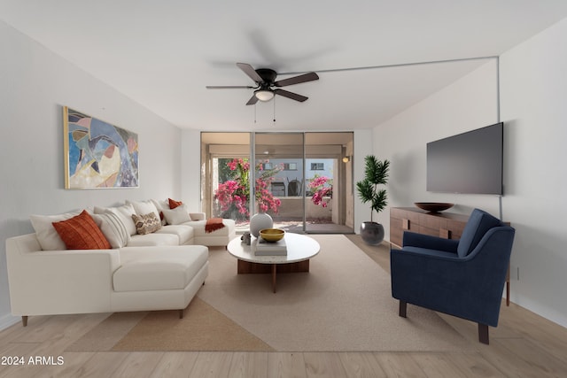 living room with ceiling fan, a wall of windows, and light hardwood / wood-style flooring