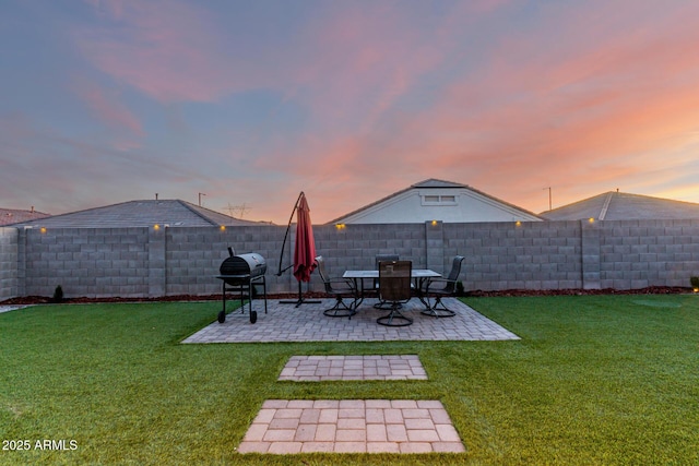 yard at dusk featuring a patio area and a fenced backyard