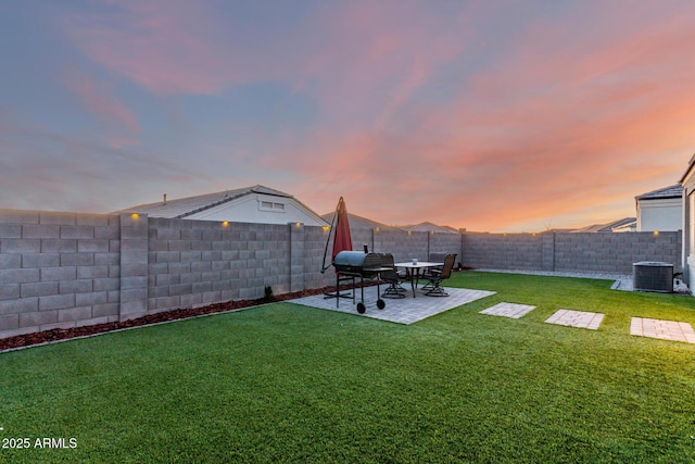 yard at dusk with a fenced backyard, a patio area, and cooling unit