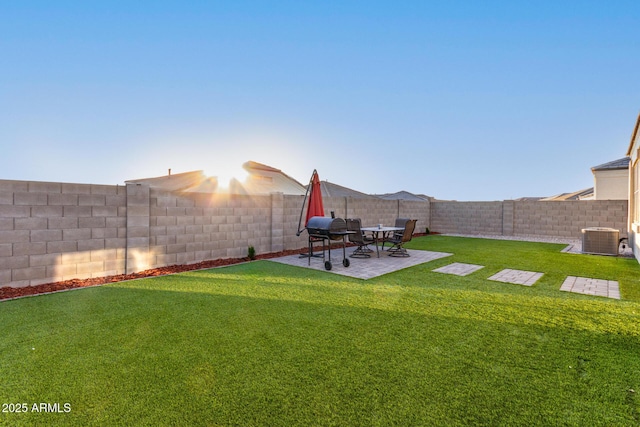 view of yard with a patio area, a fenced backyard, and central AC unit