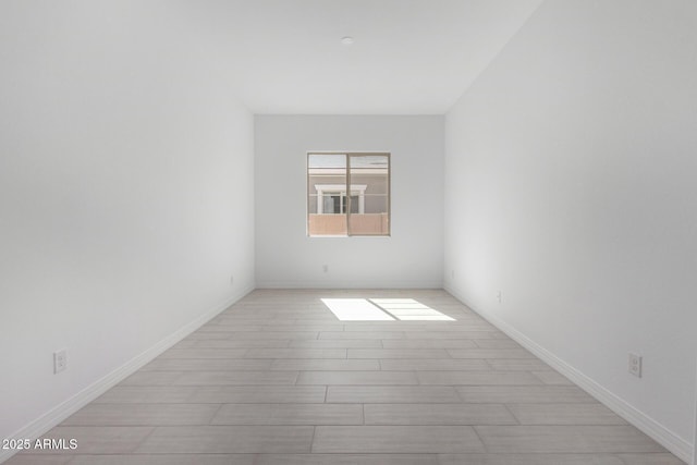 unfurnished room featuring baseboards and light wood-style floors