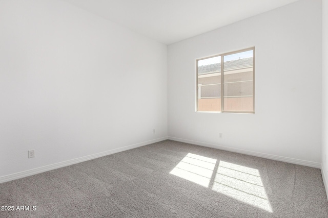 carpeted empty room featuring baseboards