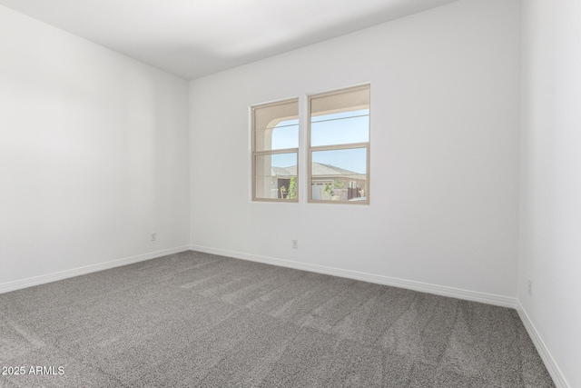 carpeted spare room with baseboards