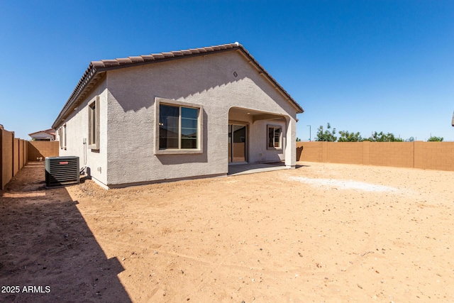 rear view of house featuring a patio, a fenced backyard, cooling unit, and stucco siding