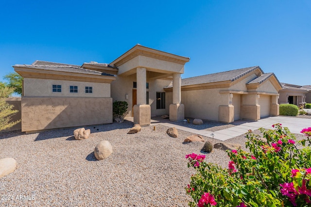 view of front of home with a tiled roof, stucco siding, driveway, and a garage