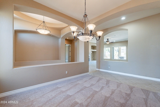 carpeted empty room featuring tile patterned flooring, baseboards, a tray ceiling, recessed lighting, and arched walkways