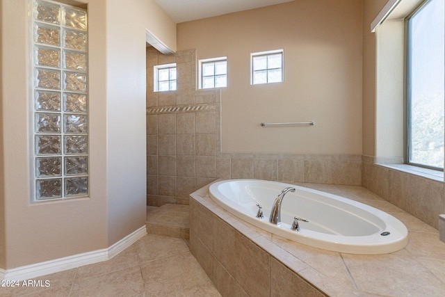 full bath featuring a bath, plenty of natural light, tile patterned floors, and walk in shower