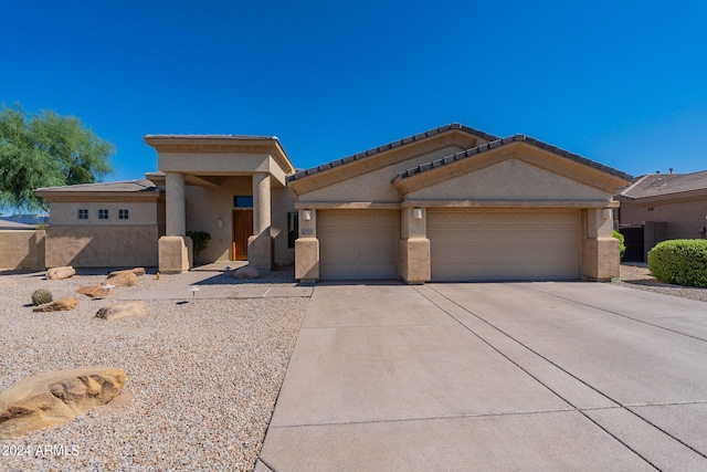 view of front of home with stucco siding, a garage, and driveway